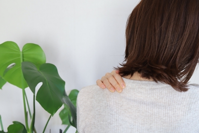 首や肩まわりに手を当てている様子