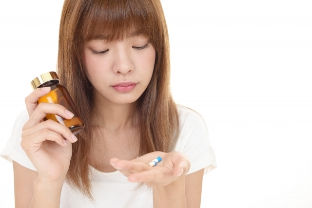 普段飲んでいる薬やサプリメントと体調の関係を考える女性