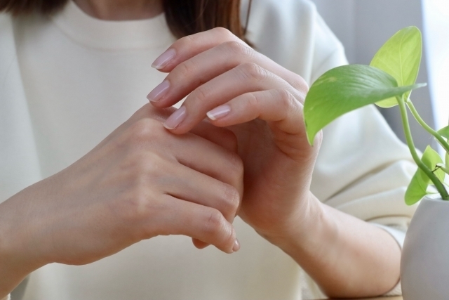 親指側の手首を気にしながら物を持つ様子